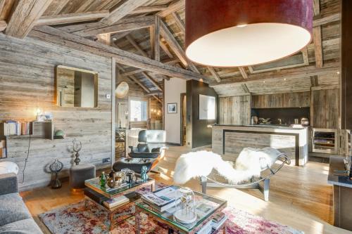 a living room with wooden walls and a large ceiling at Luxury flat 2 steps to the cable cars in Megève - Welkeys in Megève