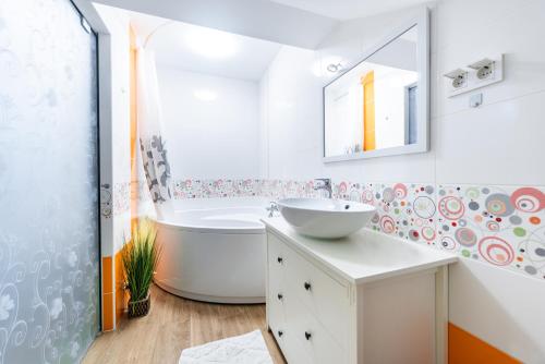 La salle de bains blanche est pourvue d'une baignoire et d'un lavabo. dans l'établissement Apartmani Majetić, à Valpovo