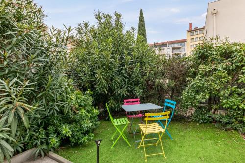 City house with garden near Part-Dieu in Lyon - Welkeys في ليون: طاولة وكراسي في حديقة بها شجيرات