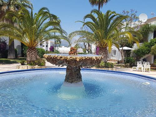 einen Brunnen inmitten eines Pools mit Palmen in der Unterkunft Casita Pepe in Jávea