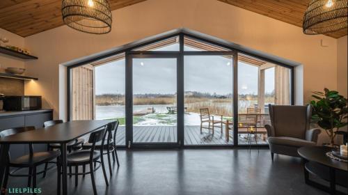 a kitchen and dining room with a view of a deck at Lielpīles in Radziņciems