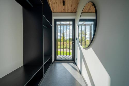 a hallway with a mirror and a door at Lielpīles in Radziņciems