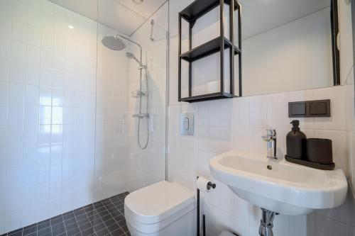 a white bathroom with a toilet and a sink at Lielpīles in Radziņciems