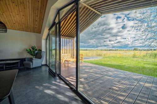 a screened in porch with a view of a field at Lielpīles in Radziņciems