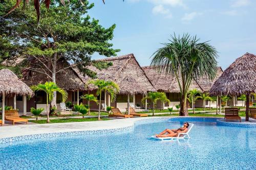 a woman laying on a chair in the pool at a resort at Irapay Amazon Lodge - Asociado Casa Andina in Padre Cocha