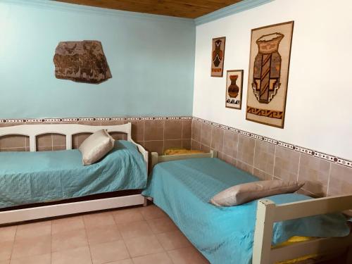 Finca Victoria في لا باندا: غرفة نوم بسريرين وصور على الحائط