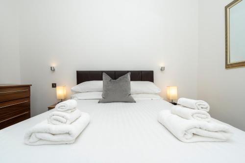 a bedroom with a white bed with towels on it at Howburn Residence Serviced Apartments in Aberdeen