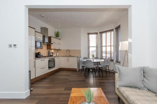 a kitchen and living room with a couch and a table at Howburn Residence Serviced Apartments - 1,2& 3 Bedroom Apartments in Aberdeen