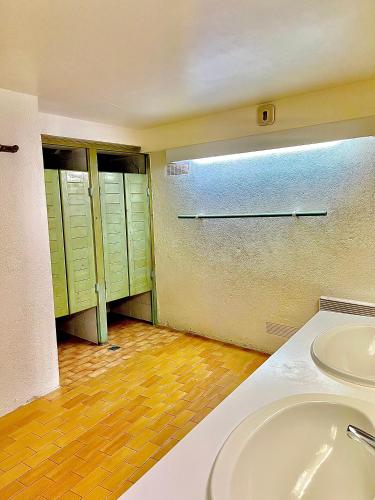 La salle de bains est pourvue d'un lavabo et de placards verts. dans l'établissement Gîte du Soula, à Mérens-lès-Vals