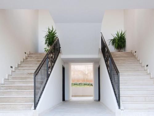 a staircase with potted plants in a white house at Villa Agapanthe in Fès