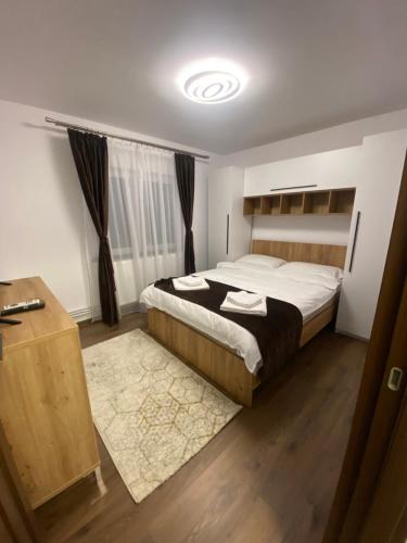 Un dormitorio con una cama grande y suelo de madera. en Apartament Eve, en Câmpulung Moldovenesc