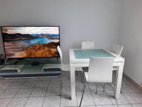 Elle comprend un bureau blanc et une télévision murale. dans l'établissement les Yuccas, Appartement Montpellier F3, à Montpellier