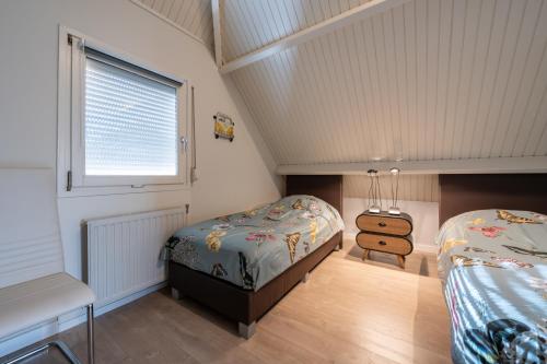 a bedroom with two beds and a window at Moerellahof, Gezin & Familie vakantiehuis aan het Veersemeer ALLEEN GEZINNEN in Wolphaartsdijk