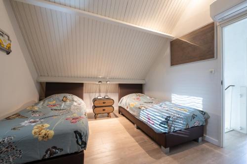 a bedroom with two beds and a window at Moerellahof, Gezin & Familie vakantiehuis aan het Veersemeer ALLEEN GEZINNEN in Wolphaartsdijk