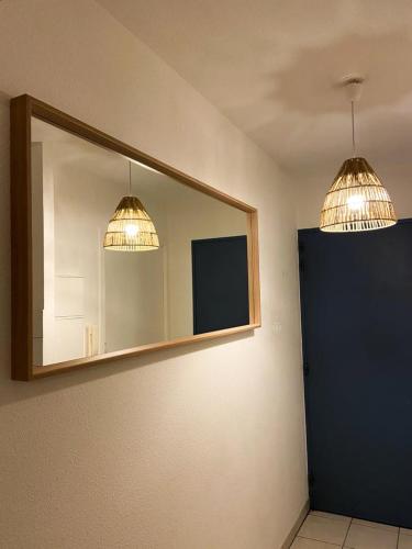 - deux lumières et un miroir dans la chambre dans l'établissement Au coeur d'Anglet, Studio Oihana - Plage et Biarritz à 10 min, à Anglet