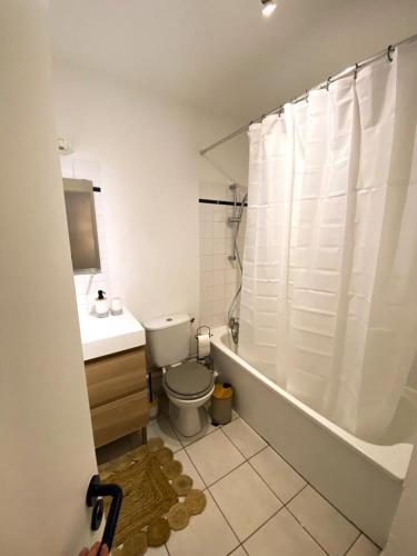 une salle de bain avec toilettes et rideau de douche dans l'établissement Au coeur d'Anglet, Studio Oihana - Plage et Biarritz à 10 min, à Anglet