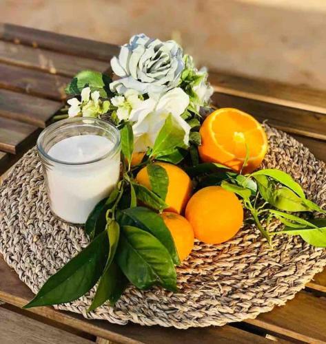 a plate with a candle and flowers and oranges at Ses cases noves Llucmajor in Llucmajor