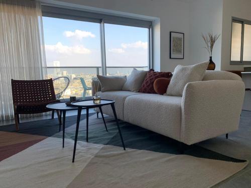 ein Wohnzimmer mit einem Sofa und einem Tisch in der Unterkunft Ace By HolyGuest in Tel Aviv