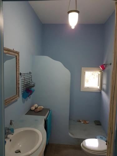 a bathroom with a sink and a toilet and a mirror at Captain Yannis in Sifnos