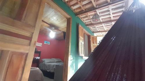 Zimmer mit einem Bett und einer Hängematte. in der Unterkunft Chalés Guigó-Cumuruxatiba in Cumuruxatiba