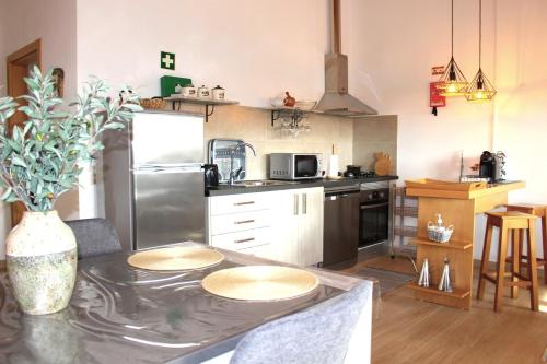 a kitchen with a table and a refrigerator at Quinta das Alfambras in Aljezur