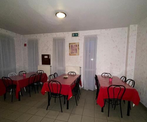 a dining room with tables and chairs with red table cloths at Panama Motel in Székesfehérvár