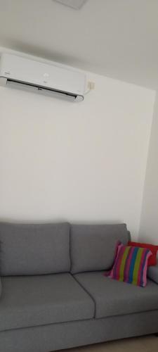 a gray couch with a colorful pillow in a room at Departamento126 in Junín