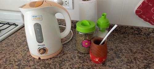 a white blender sitting on a counter with jars of spices at Departamento126 in Junín