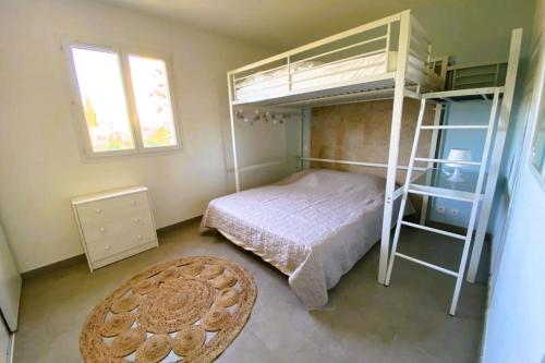 - une chambre avec des lits superposés et un tapis dans l'établissement Appartement Lena 6 pers piscine 500 m plage, à Sainte-Lucie de Porto-Vecchio