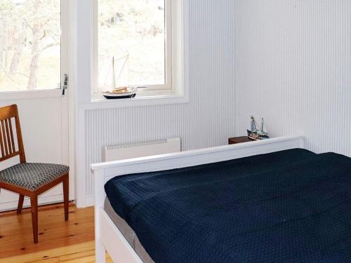 1 dormitorio con 1 cama, 1 silla y 1 ventana en Holiday home YNGSJÖ, en Yngsjö