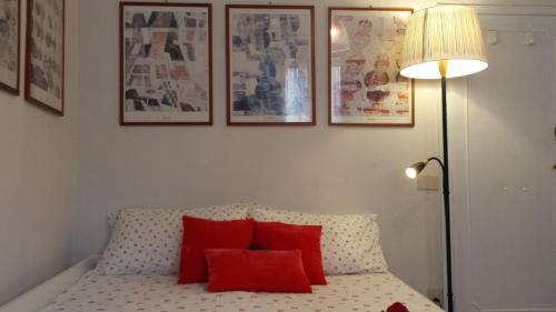 フィレンツェにあるMagico Risveglio Piazza Signoriaのベッドルーム1室(赤い枕とランプ付きのベッド1台付)