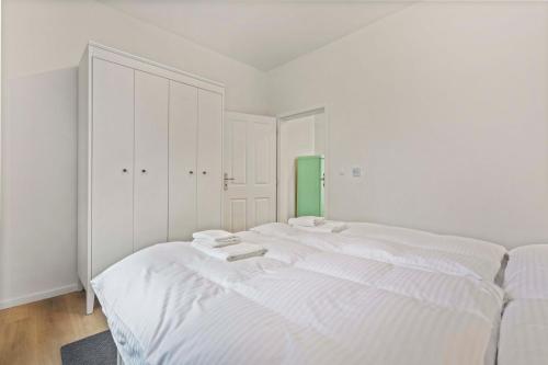 a white bedroom with a large white bed in it at Byt v harmónii s prírodou in Modra