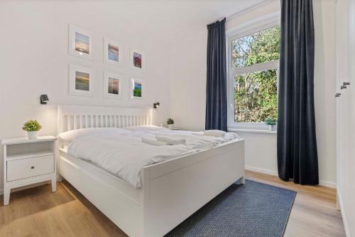 een witte slaapkamer met een wit bed en een raam bij Byt v harmónii s prírodou in Modra