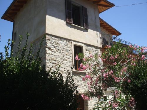 a stone house with pink flowers in front of it at Cà Fedora in Bagnone