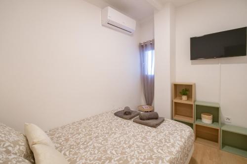 a bedroom with a bed and a flat screen tv at Self check-in! Apartment in the heart of Málaga! in Málaga
