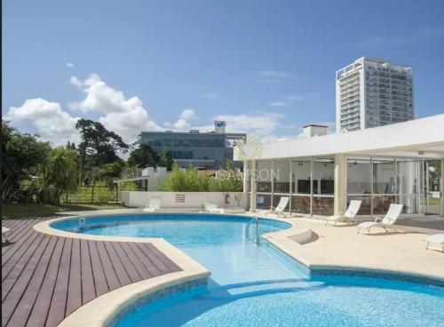 una piscina con sillas y un edificio en Torre Amadeus 203, en Punta del Este