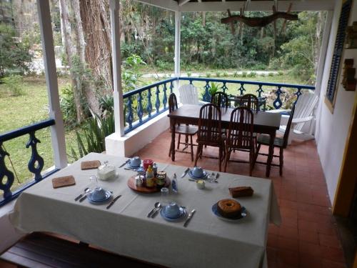 einen Tisch mit einem Teller Essen auf einer Veranda in der Unterkunft Pouso Donana Cama e Café in Itaipava