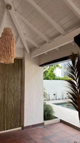 a porch with a wooden door and a ceiling at LA CURVA Casa de Playa in Villa Gesell