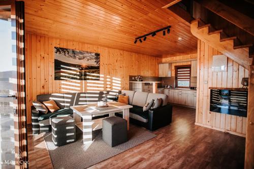 a living room with a couch and a table at Chaty na Cholewicy Domki Całoroczne in Solina