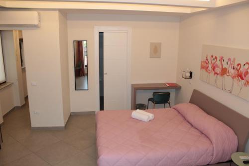 a bedroom with a pink bed and a desk at Margiò House in Sorrento