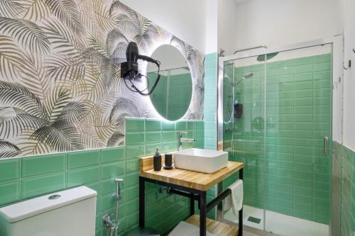 a bathroom with a sink and green tiles at Malaga City Suites in Málaga