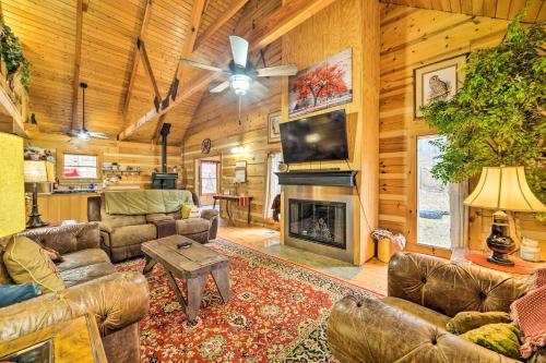a living room with leather furniture and a fireplace at Quiet Cabin Retreat on 30 Acres Near Kentucky Lake in New Concord