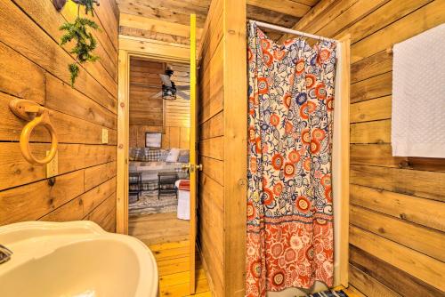 a bathroom with a toilet and a shower backdoor at Quiet Cabin Retreat on 30 Acres Near Kentucky Lake in New Concord