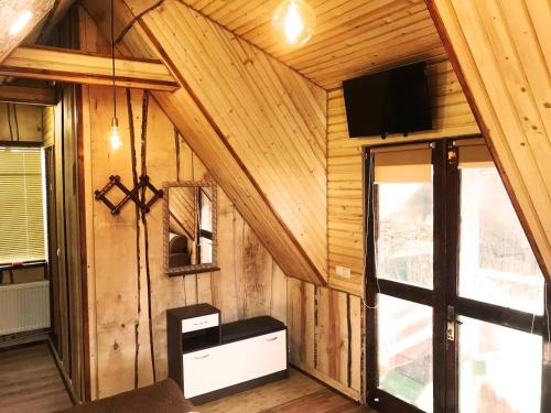 a room with wooden walls and a tv on the wall at Lavanda cottage in Verkhovyna