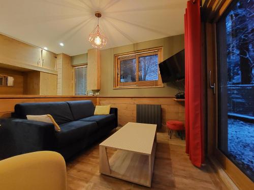 a living room with a couch and a table at Clos Bois Joli in Brides-les-Bains