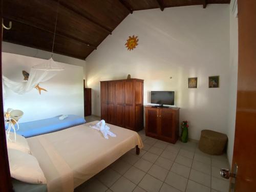 ein Schlafzimmer mit einem großen Bett und einem TV in der Unterkunft Pousada Isca do Sol in Pecém