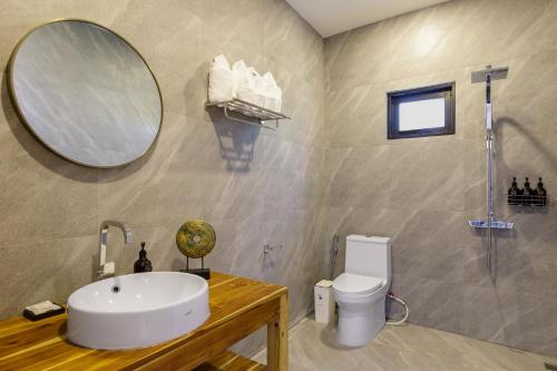 ein Badezimmer mit einem Waschbecken, einem Spiegel und einem WC in der Unterkunft Villa primor Chaloklum Koh phangan in Chaloklum