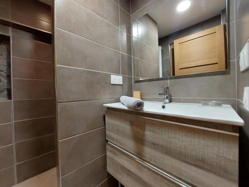 une salle de bain avec un lavabo et un miroir dans l'établissement Clos Bois Joli, à Brides-les-Bains