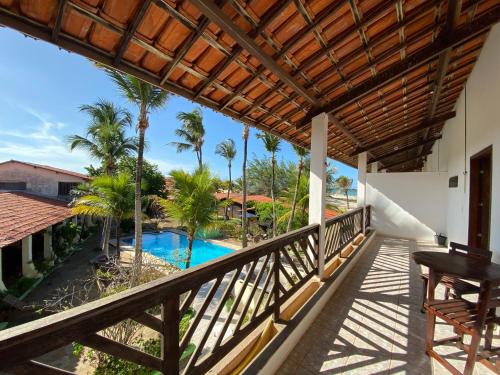 uma varanda com vista para uma piscina e palmeiras em Pousada Isca do Sol em Pecém