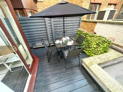 une terrasse avec un parasol, une table et des chaises dans l'établissement LUXURIOUS Terrace 2 Bedrooms in Relaxing Covent Garden Apartment, à Londres